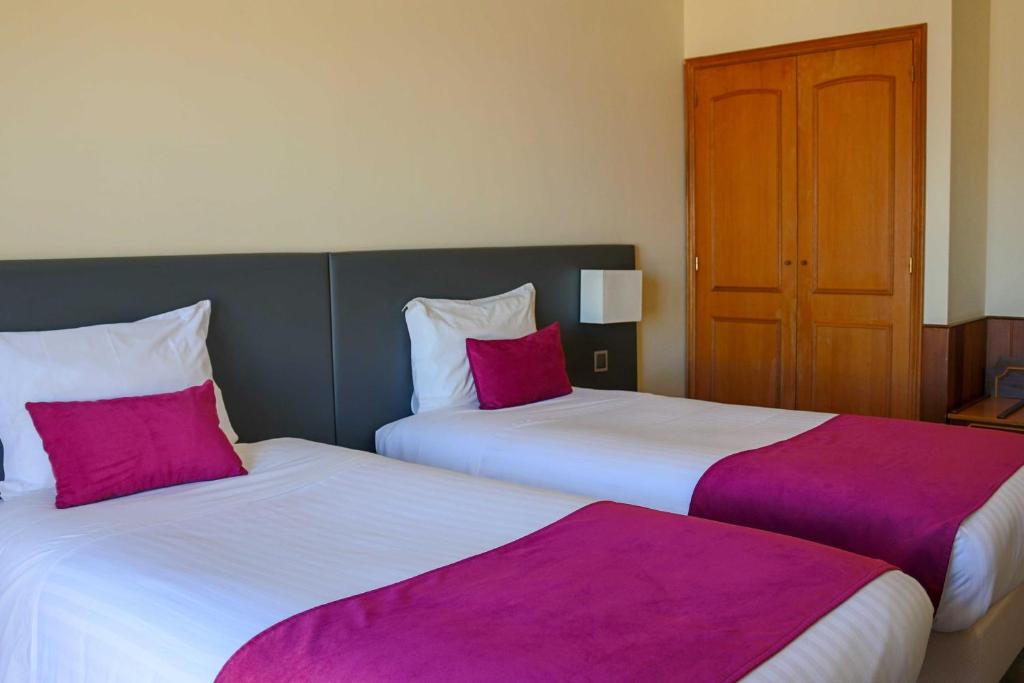 two beds sitting next to each other in a hotel room at Hotel Horta in Horta