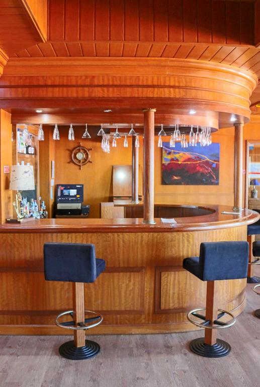 a bar in a restaurant with two blue bar stools at Hotel Horta in Horta