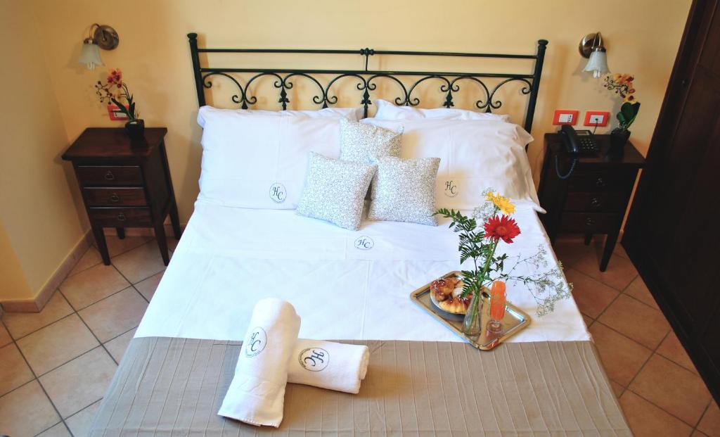 a bed with a white blanket and pillows on top of it at Hotel Columbia in Palermo