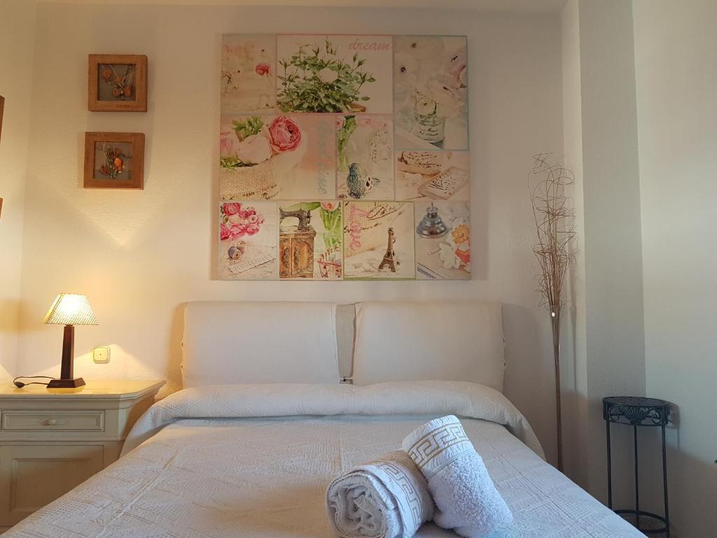 Apartamento turístico en Sevilla في إشبيلية: غرفة نوم بسرير ودهان على الحائط