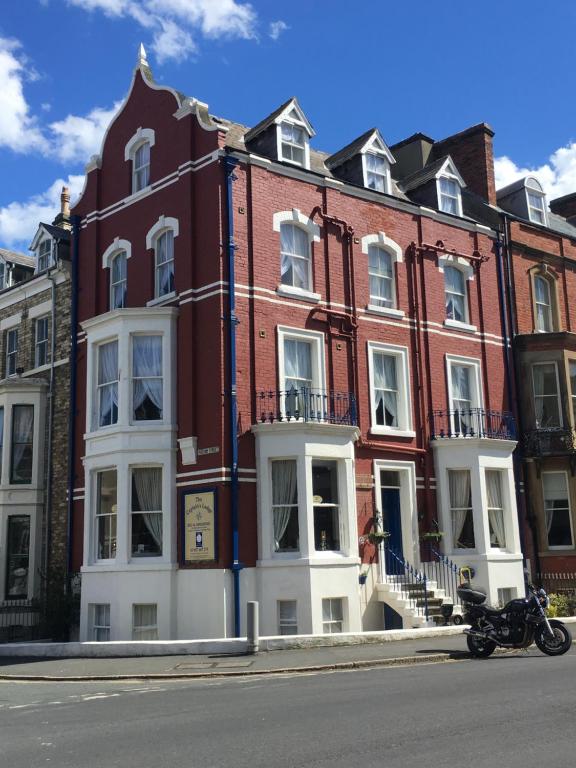 una motocicleta estacionada frente a un edificio en The Captain's Lodge Room Only accommodation, en Whitby