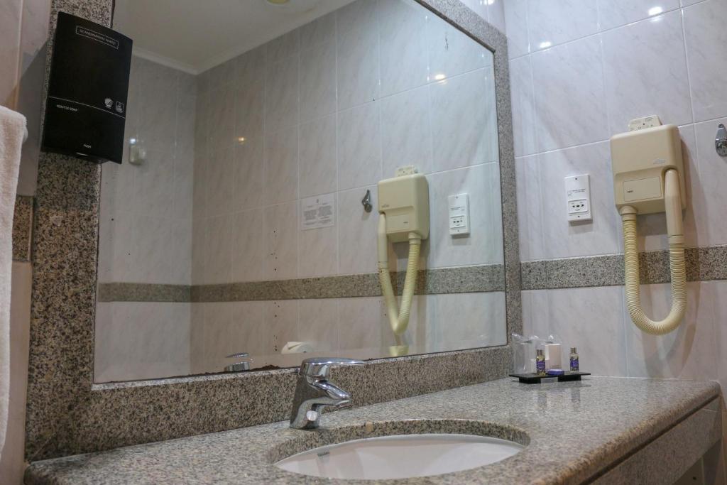 a bathroom with a sink and a mirror at Hotel Horta in Horta