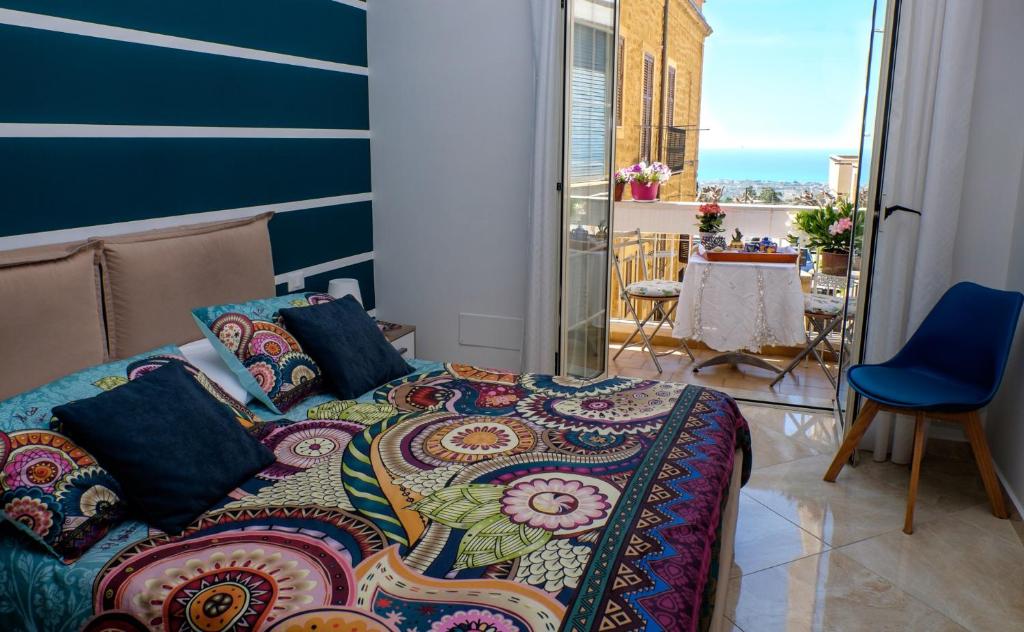 a bedroom with a bed and a balcony with a table at La Passeggiata di Girgenti in Agrigento