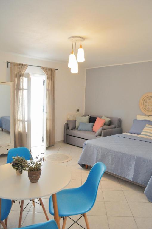 a bedroom with a bed and a table and chairs at Casa Valeri I - Charming Cycladic Studio in Naxos Town in Naxos Chora