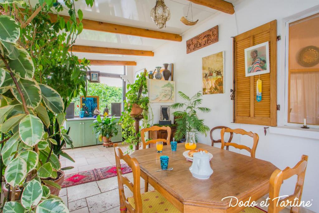 - une table en bois dans une pièce ornée de plantes dans l'établissement Green house with garden - Dodo et Tartine, à La Valette-du-Var