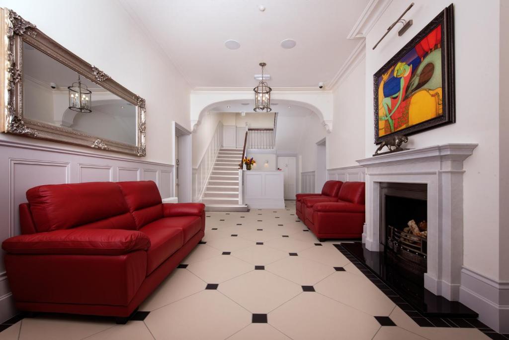 a living room with red couches and a fireplace at Best Luxury Apart Hotel in Oxford- Beechwood House in Oxford