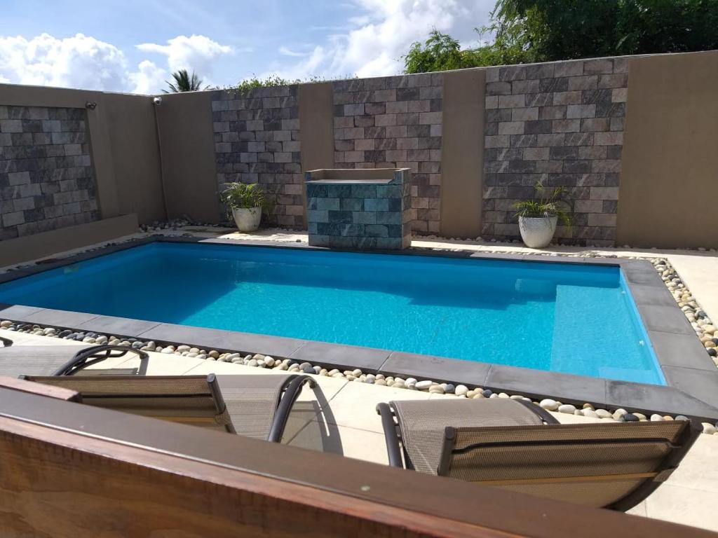 - une piscine dans une arrière-cour entourée de chaises dans l'établissement Villa Oceane, à Pereybere