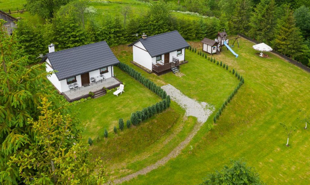 uma pequena casa no topo de um campo verde em Domki w Zieleni em Polańczyk