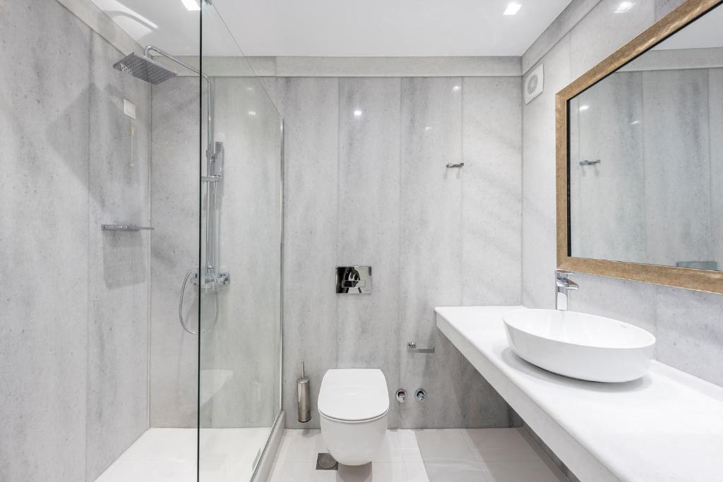 a bathroom with a toilet and a sink and a shower at Saint George Hotel in Chrissi Akti