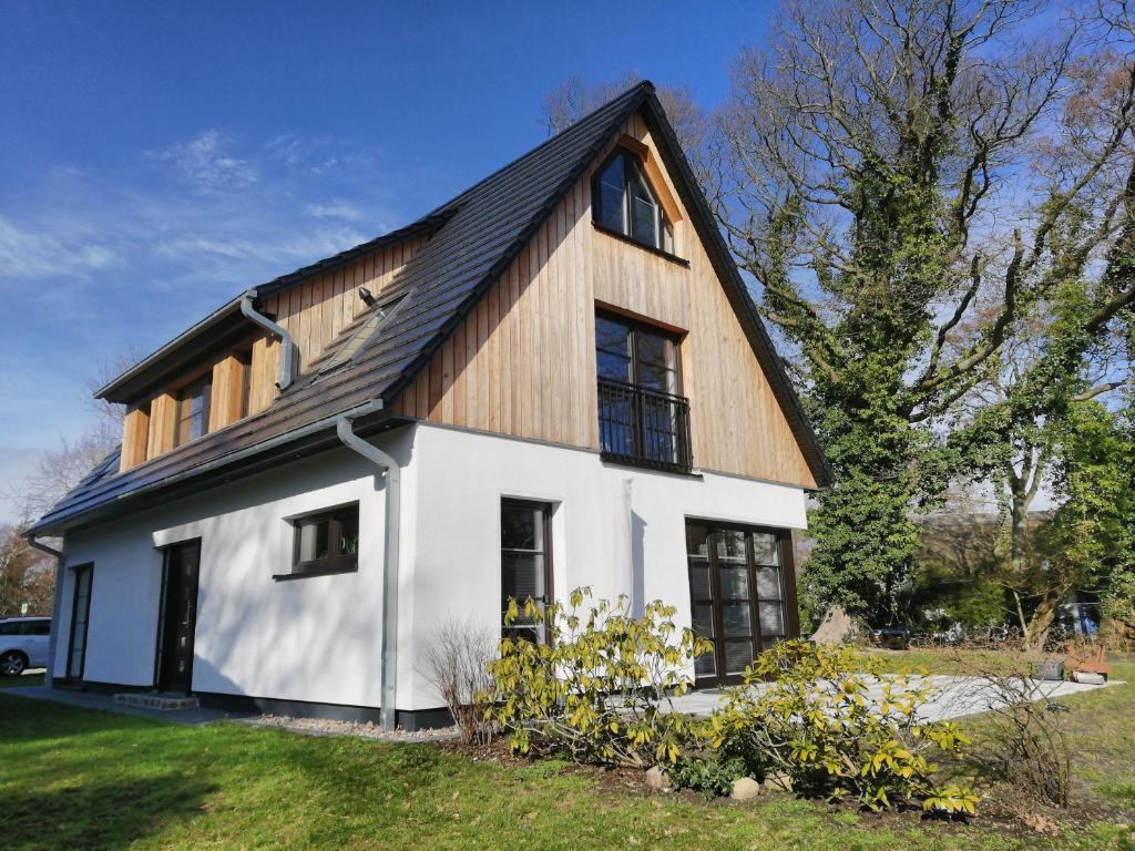 a white house with a gambrel roof at Darßer Strandgut - Haus Ahrenshooper Holz in Ahrenshoop