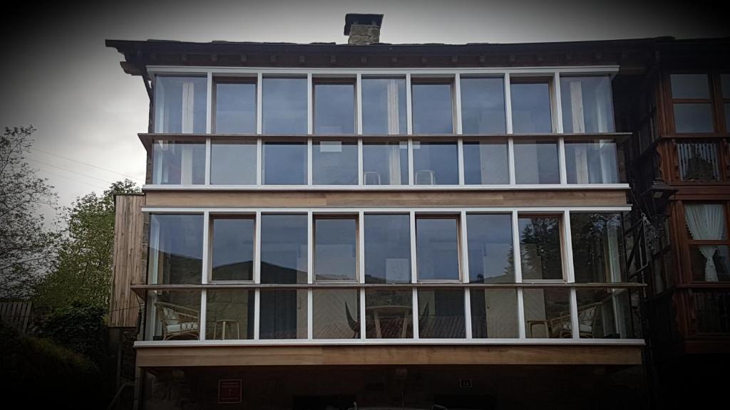 a building with large glass windows on the side of it at Apartamentos Casa Frutos in Vega de Pas