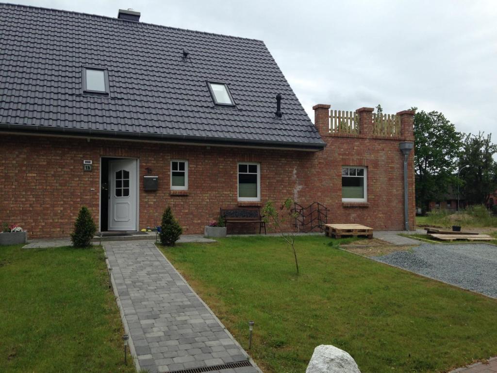a red brick house with a yard with a bench at Kornblume in Rabenholz