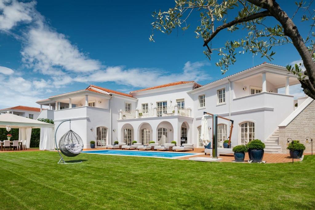 a large white house with a large yard at Villa Ivana in Vabriga