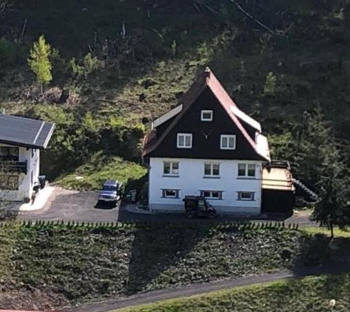 ein großes weißes Haus mit schwarzem Dach in der Unterkunft Haus Sonnenblick in Oberschönau