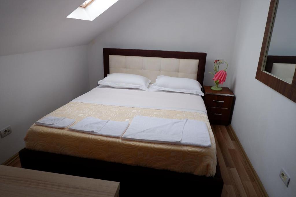 a bedroom with a large bed with white sheets and pillows at Hotel Kings Apartments in Kolgecaj