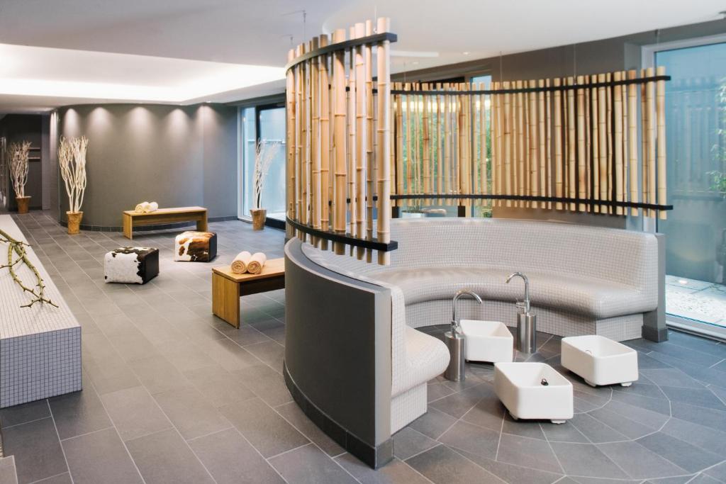 a living room with a couch and a table at Mövenpick Hotel Stuttgart Airport in Stuttgart