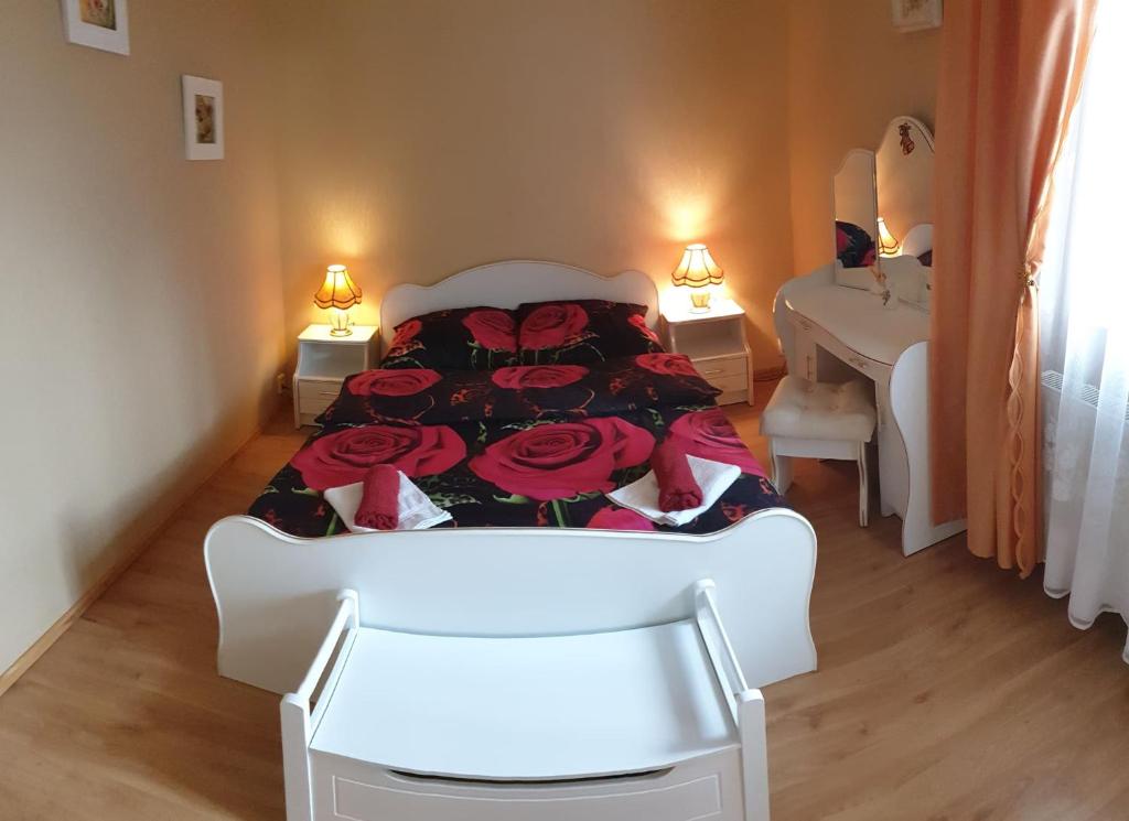 a bedroom with a bed with red roses on it at Pokoje Gdynia Orłowo in Gdynia