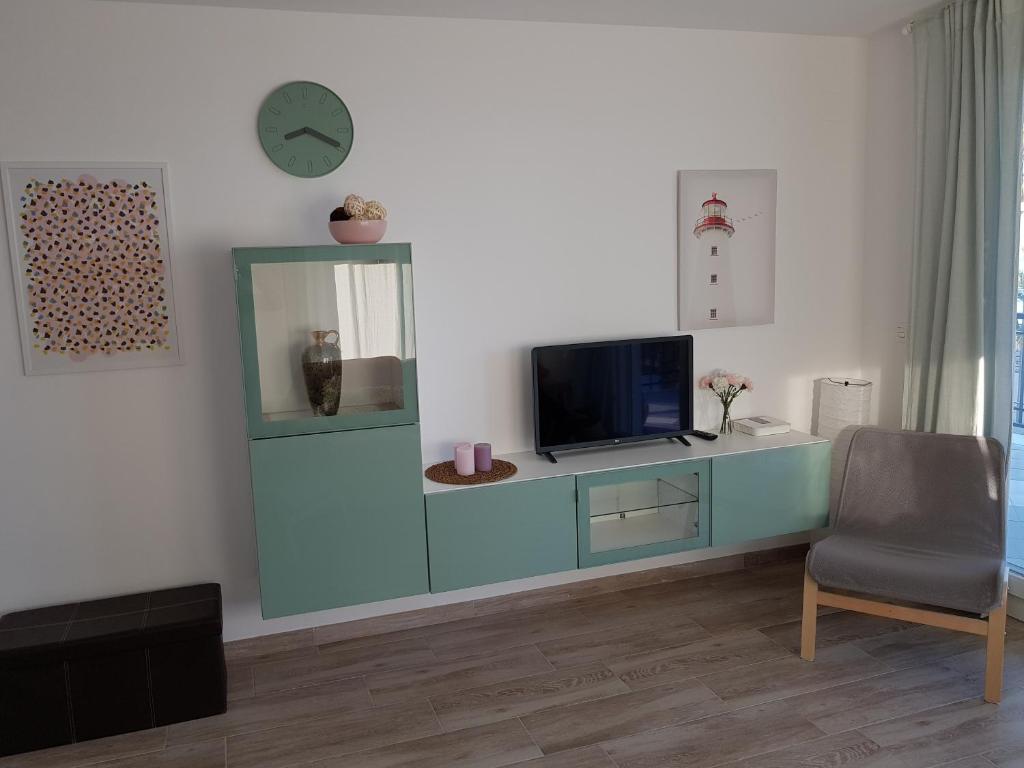 Televízia a/alebo spoločenská miestnosť v ubytovaní Apartamento Apolo