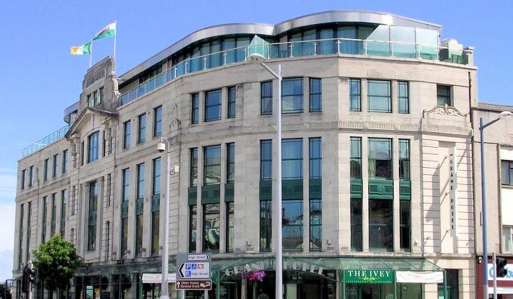 un grand bâtiment avec un drapeau en haut dans l'établissement The Grand Hotel, à Swansea