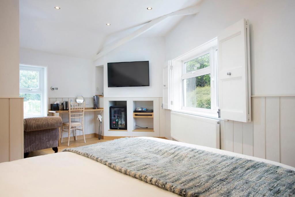 a bedroom with a bed and a tv on the wall at Hotel Continental in Whitstable