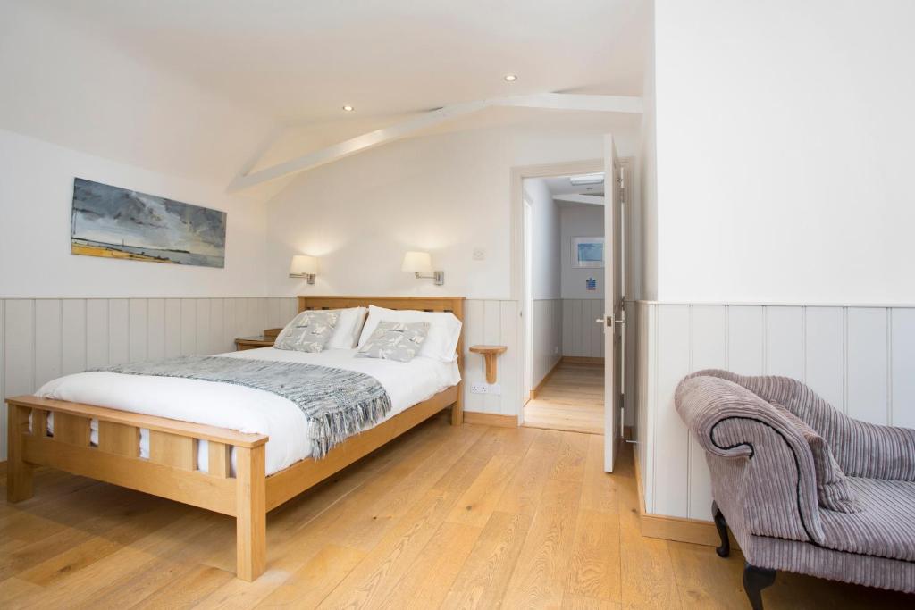 a bedroom with a bed and a chair at Hotel Continental in Whitstable