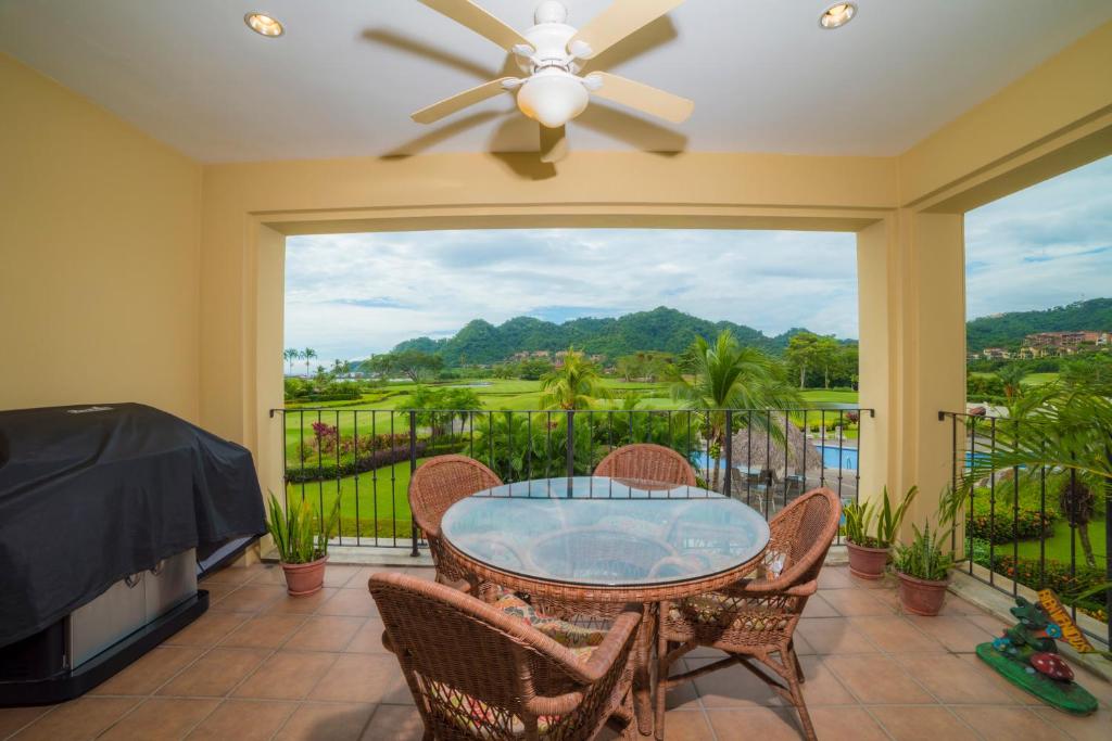 eine Terrasse mit einem Glastisch und Stühlen sowie einem Fenster in der Unterkunft Los Suenos Resort Del Mar 4G by Stay in CR in Herradura