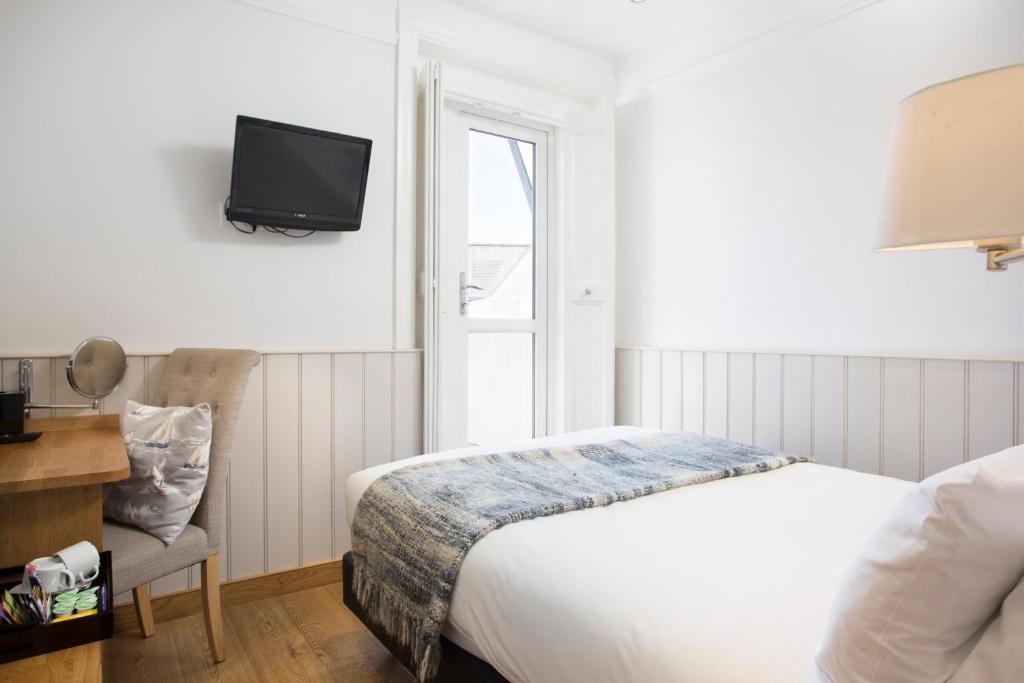 a bedroom with a bed and a tv on the wall at Hotel Continental in Whitstable
