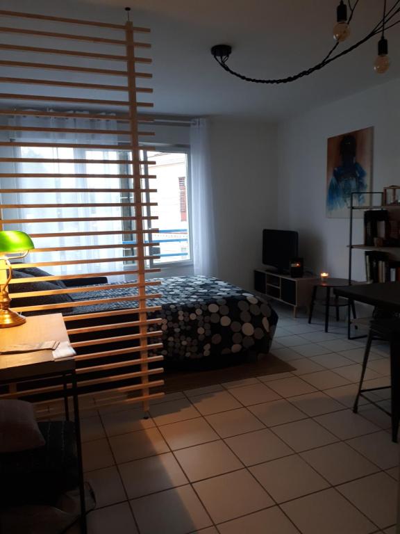 a bedroom with a bed and a large window at Talence, studio cosy 27 M2, Bordeaux 10 mn en tram in Talence