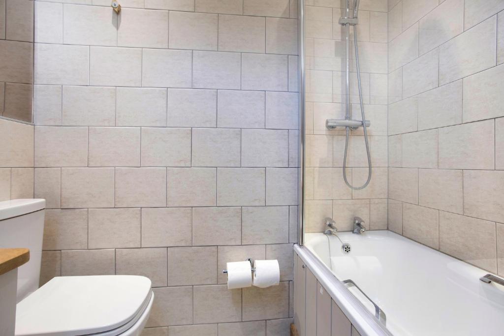a bathroom with a tub and a toilet and a shower at Hotel Continental in Whitstable
