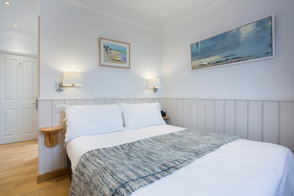 a bedroom with a bed and two pictures on the wall at Hotel Continental in Whitstable