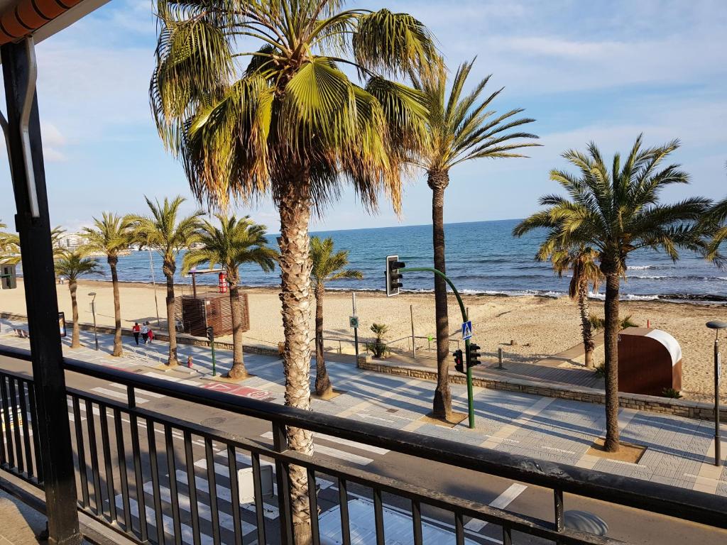 uma vista para uma praia com palmeiras e para o oceano em Apartamento Apolo em Salou