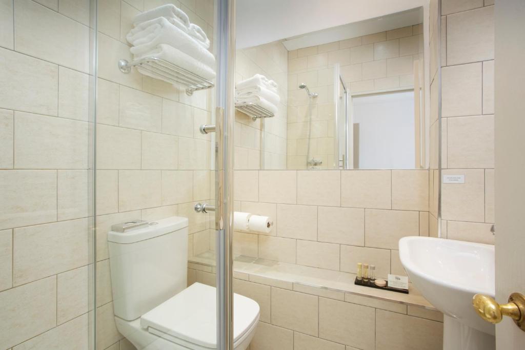 a white bathroom with a toilet and a sink at Hotel Continental in Whitstable