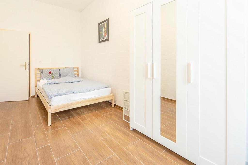ein Schlafzimmer mit einem Bett und einem Schrank in der Unterkunft Simple Rooms - Yellow Inn in St. Gallen