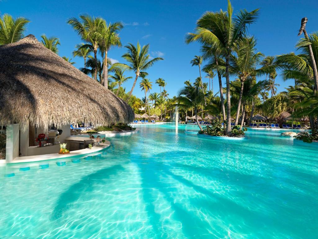 - une piscine dans un complexe avec des palmiers dans l'établissement Meliá Caribe Beach Resort-All Inclusive, à Punta Cana