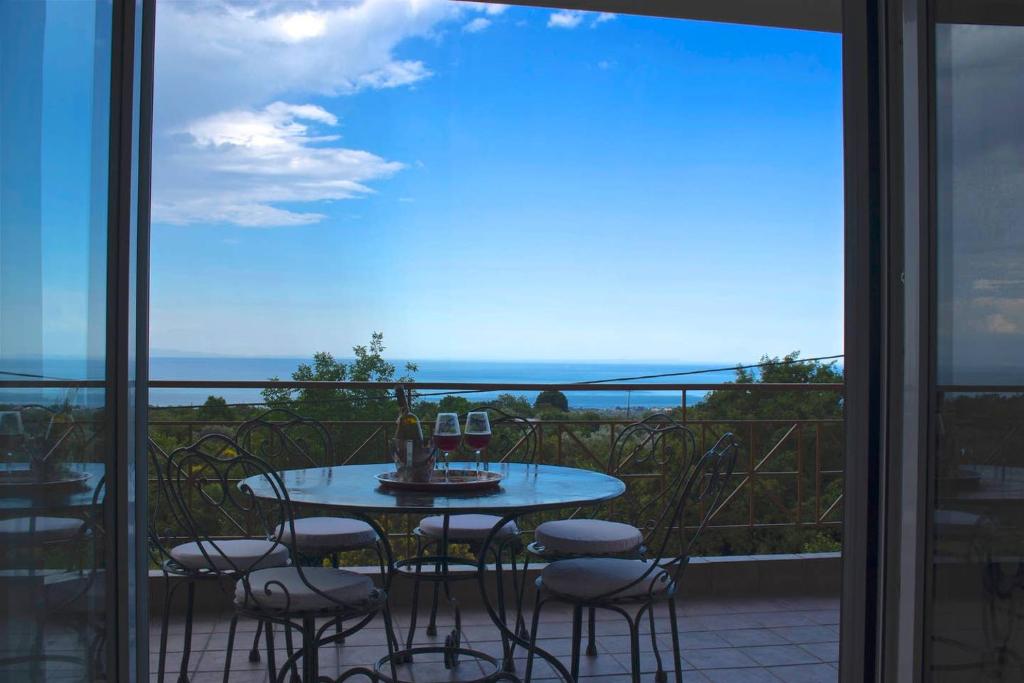 a table and chairs on a balcony with a view of the ocean at Luxurious Apartment With Sea & Mountain View in Litochoro