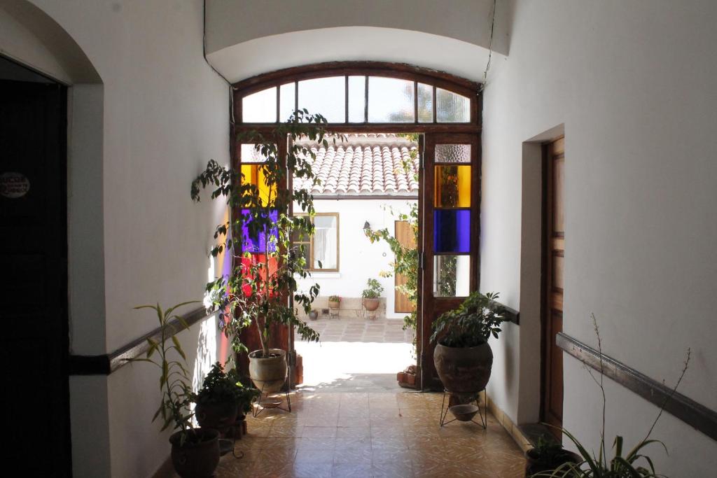 un couloir avec des plantes en pot et une porte ouverte dans l'établissement Wasi, à Sucre