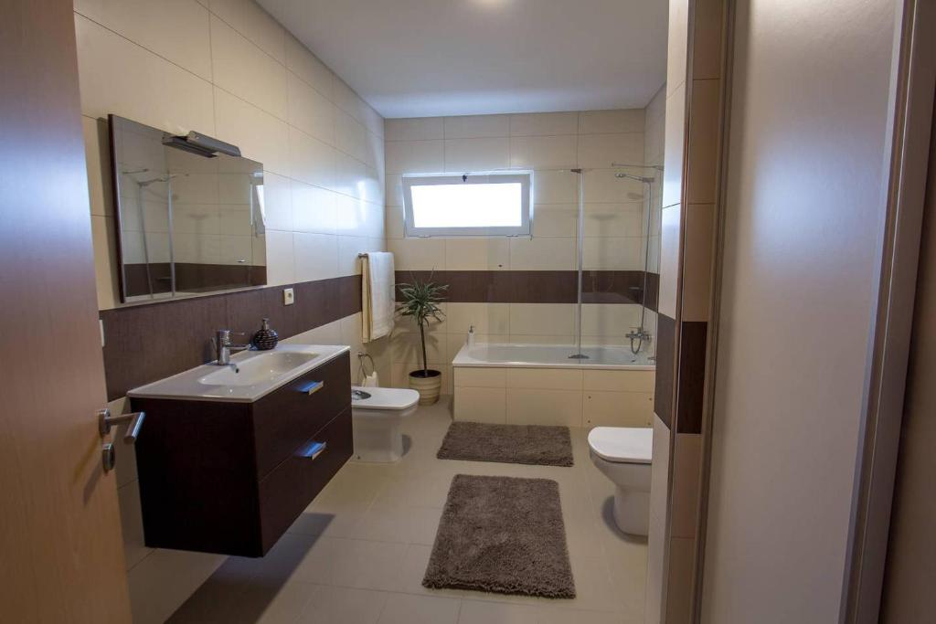 a bathroom with a sink and a toilet and a tub at Quinta das Perdizes - Premium in Ponta Delgada