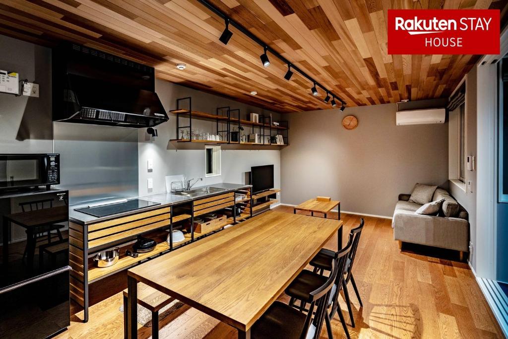 uma cozinha e sala de jantar com uma grande mesa de madeira em Rakuten STAY HOUSE x WILL STYLE Hachimanbori em Omihachiman