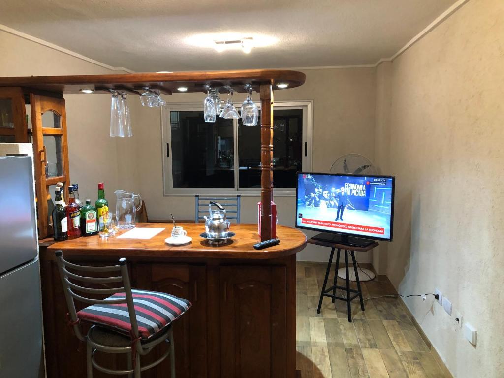 a bar in a kitchen with a television on a counter at Bellísimo Departamento in Mariano J. Haedo