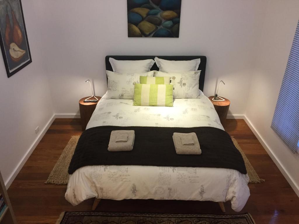 a bedroom with a large bed with two lamps at Smiths Lake House in Smiths Lake