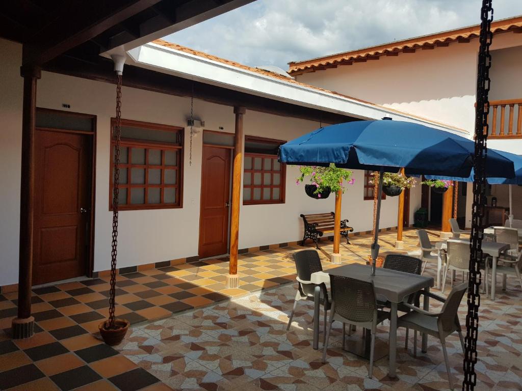 een patio met een tafel en stoelen en een parasol bij Hotel La Ceiba in Valparaíso