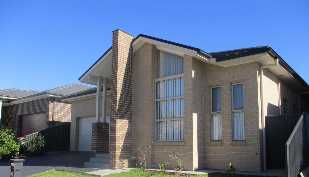 uma grande casa de tijolos com um céu azul em Edmondson Villas Sydney em Horningsea Park