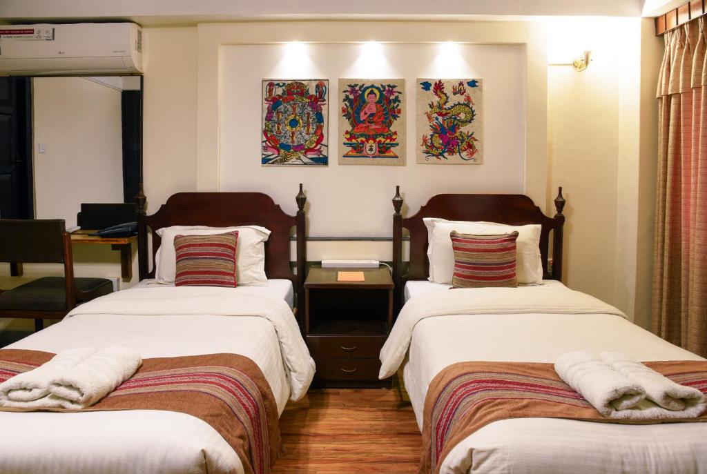1 dormitorio con 2 camas y toallas. en Nepal Pavilion Inn en Katmandú
