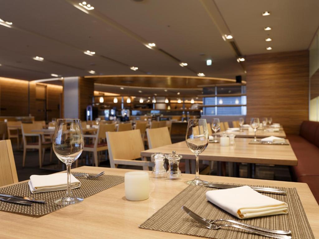 a restaurant with tables and chairs with wine glasses at Haneda Excel Hotel Tokyu Haneda Airport Terminal 2 in Tokyo