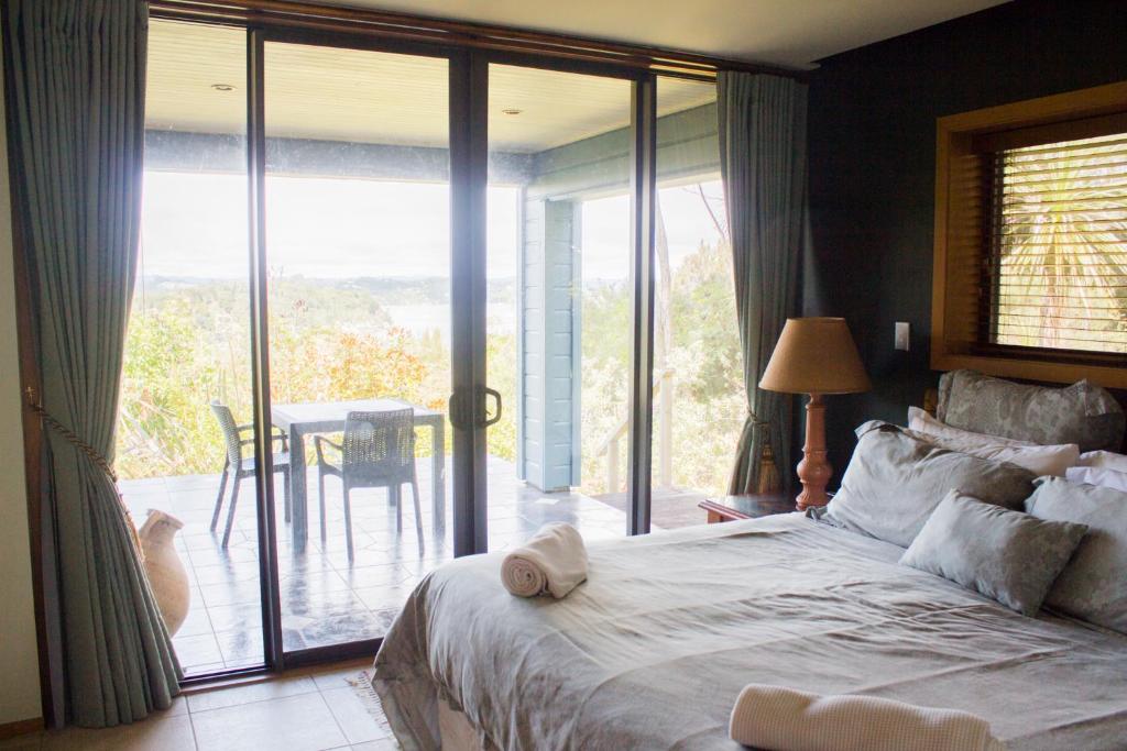 a bedroom with a bed and a sliding glass door at Titore Lodge in Russell