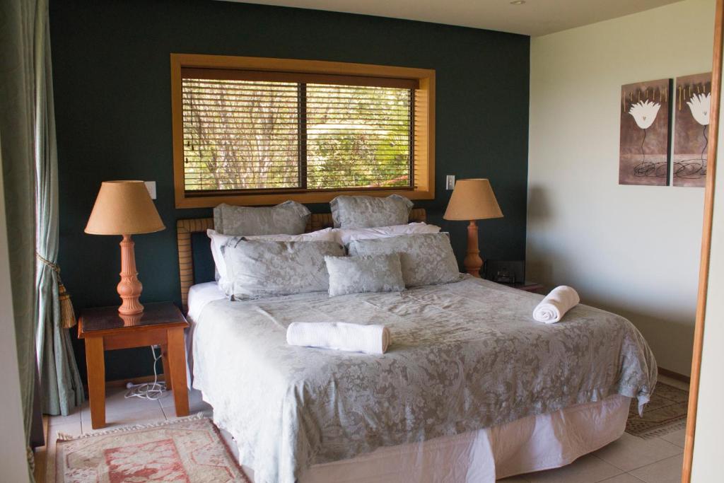 a bedroom with a bed with two lamps and a window at Titore Lodge in Russell
