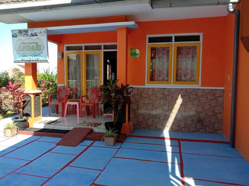 una casa con paredes de color naranja, mesa y sillas en Homestay Andari, en Batu