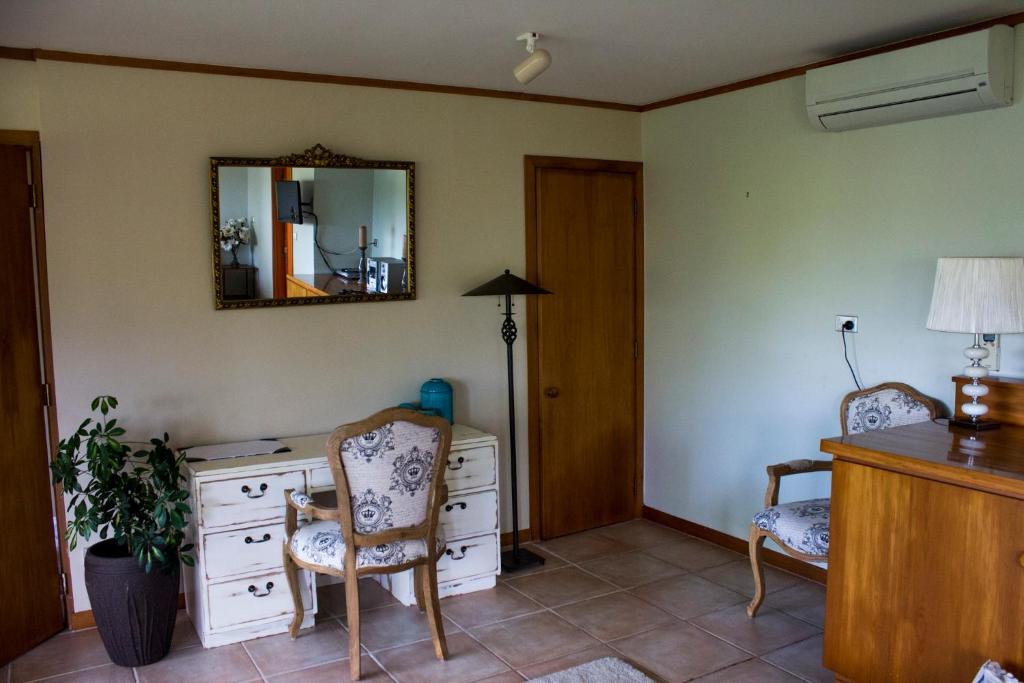 a room with a desk with two chairs and a mirror at Titore Lodge in Russell