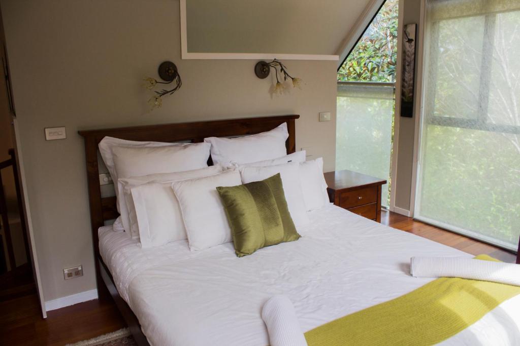 a bedroom with a white bed with white pillows at Titore Lodge in Russell