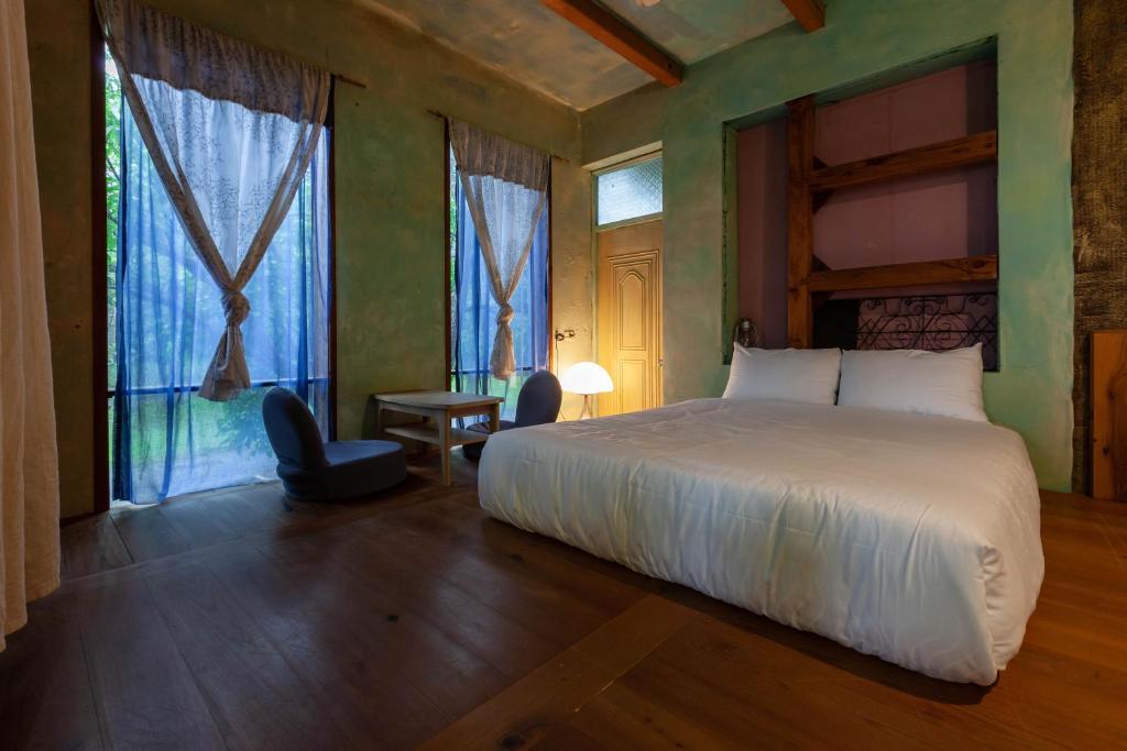 Un dormitorio con una cama y una ventana grande. en 有客森林, en Luodong